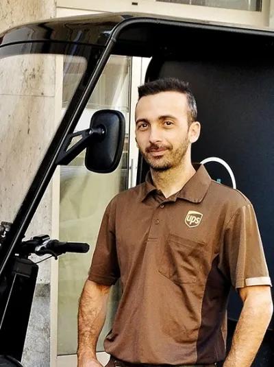 Two young persons standing in front of eCargo Bikes, one of them branded with UPS.