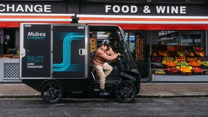 Electric cargo vehicle parked outside a neighborhood grocery store